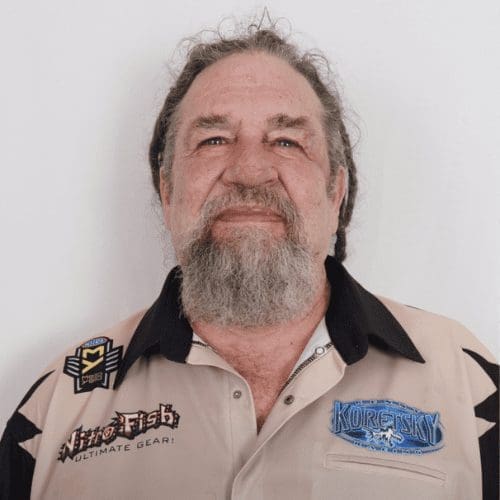 Image of a man with a beard wearing a beige shirt featuring logos, representing the team behind AIS Commercial Construction's commitment to quality and craftsmanship in commercial projects.